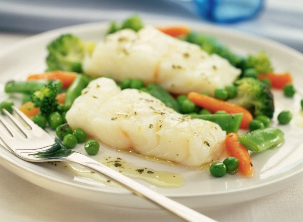 A plate of cooked fish and vegetables