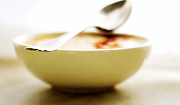 A bowl of soup with a spoon sitting on top