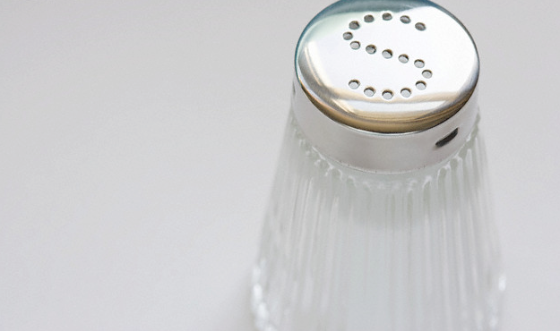 A glass salt shaker with an s on the top