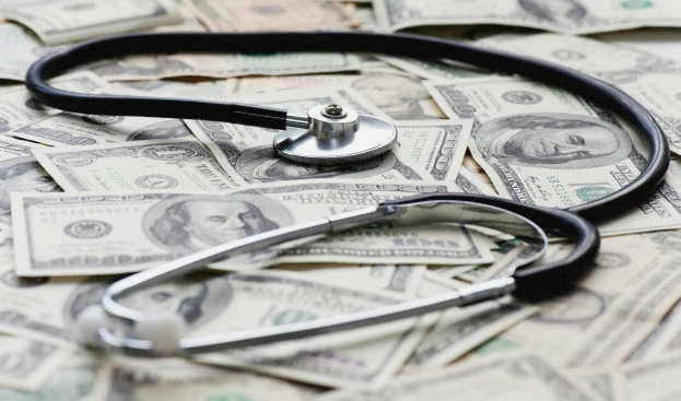 A stethoscope sitting on a pile of money