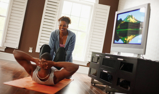 A couple doing sit-ups on the floor