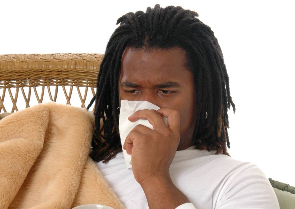 young black man blowing nose