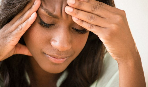 A woman with a headache touching her forehead