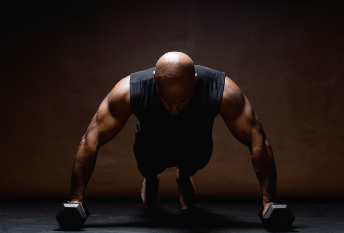 A man doing push-ups with weights
