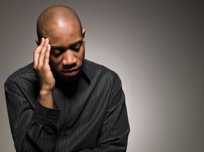 african american man rubbing his head