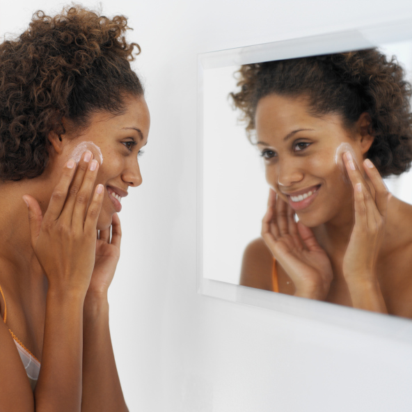 woman in mirror face cream