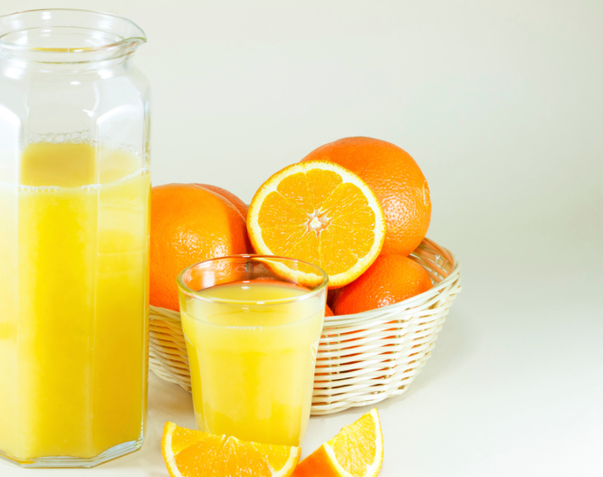 oranges with a glass and jug of orange juice
