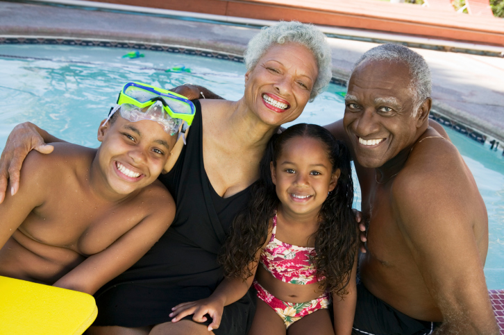 grandparents and grandchildren posing by swimming area