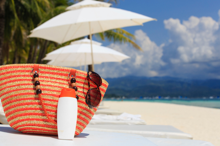 bag, sun glasses and suncream on tropical beach