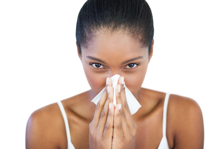 African American Black woman with cold blowing her nose