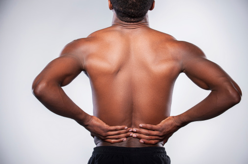 man holding lower back appearing to be in pain, backache