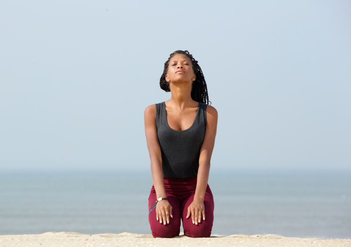 Young woman meditating at the beach