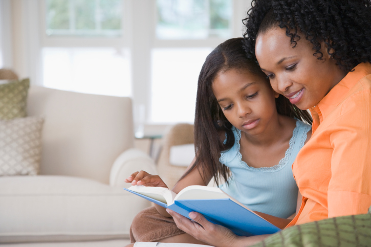 side profile of mother reading to her daughter