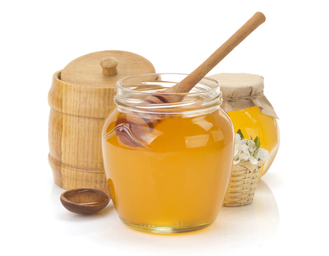 glass jar full of honey and stick