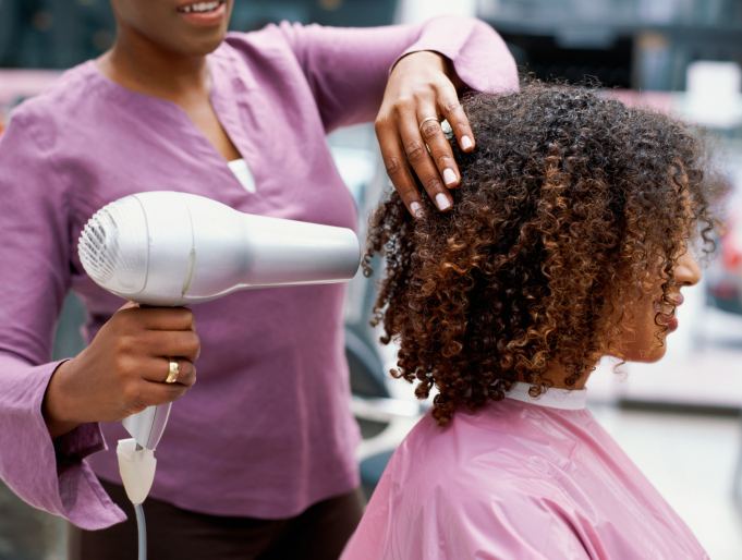 Side profile of a woman having her hair dried with a hair dryer