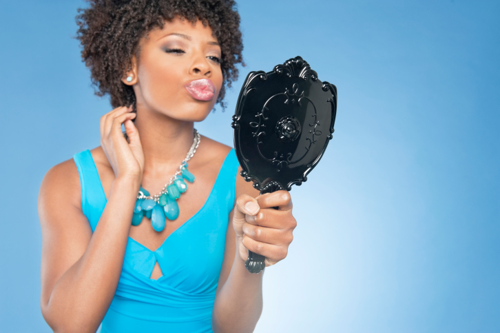 woman puckering lips in mirror