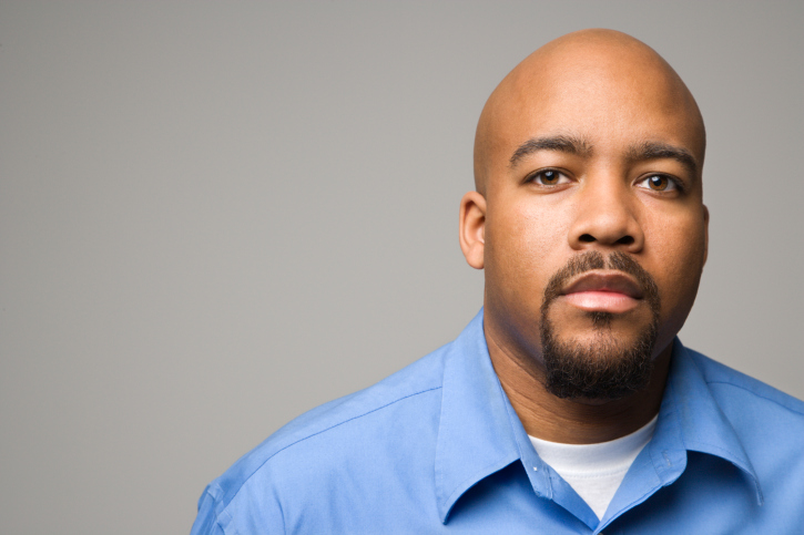 Portrait of African American man against gray background.