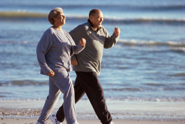 African American senior couple walking on the beach