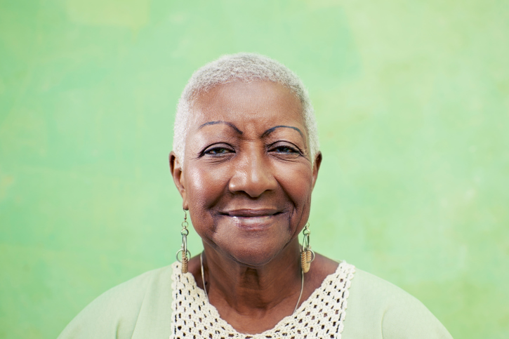 older woman smiling green background