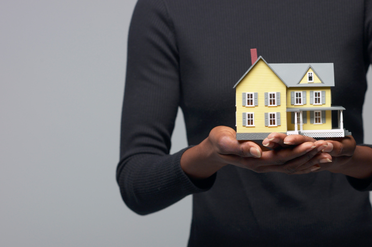 woman holding miniature house