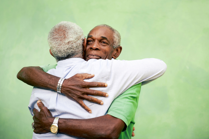 two older gentlemen hugging
