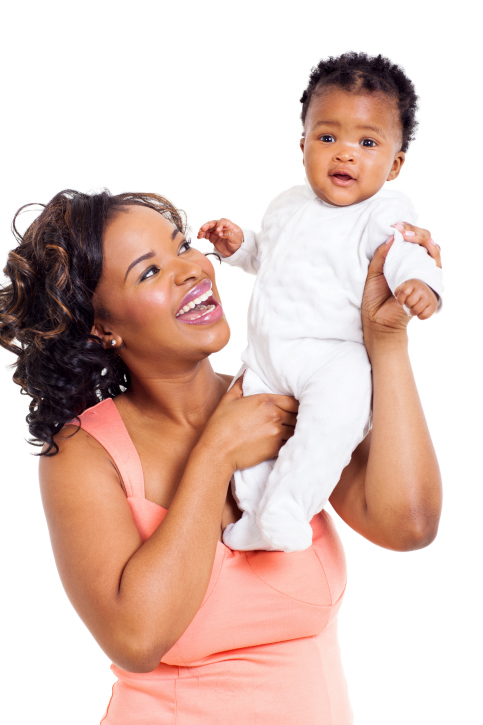 mom holding up baby girl