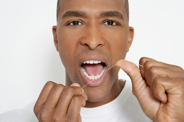 African American Black man flossing teeth