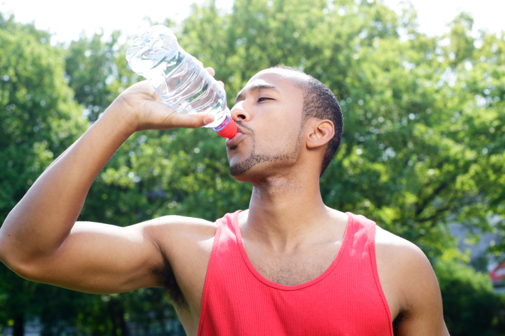 man outside drinking water bottle