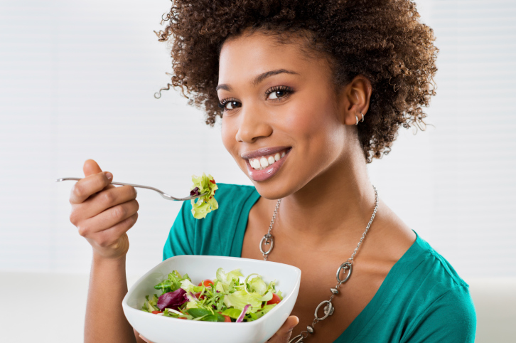 woman eating salad smiling
