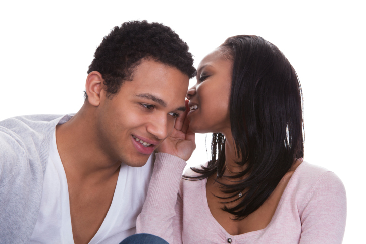 woman whispering in mans ear