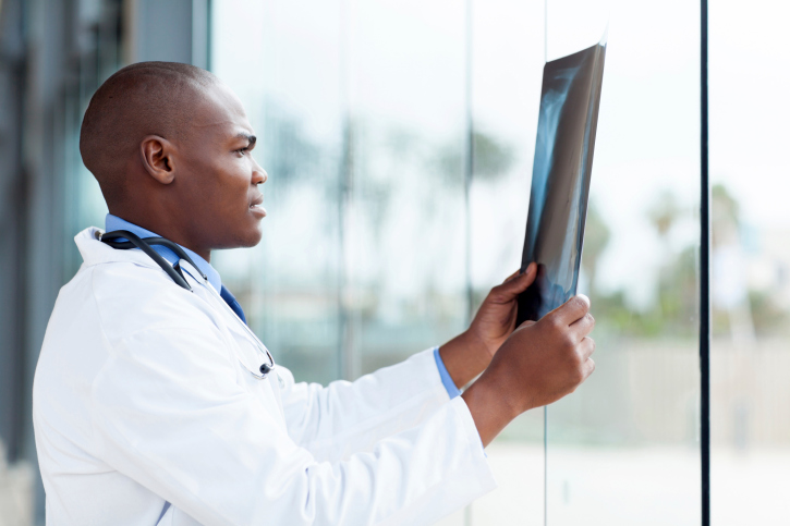 black doctor looking at x-ray