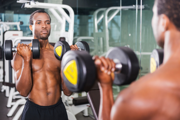 man lifting weights in a mirror