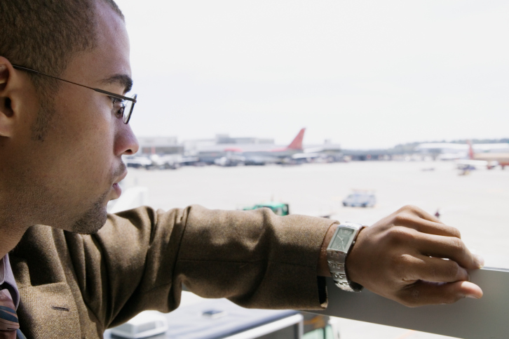 businessman looking at watch airport