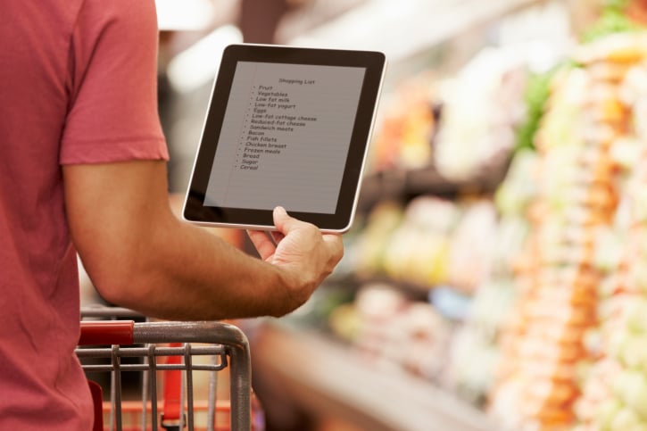 African American man grocery shopping with tablet