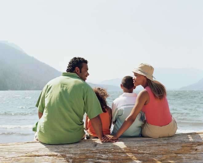 family sitting on lake