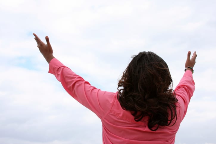 woman with hands to the sky