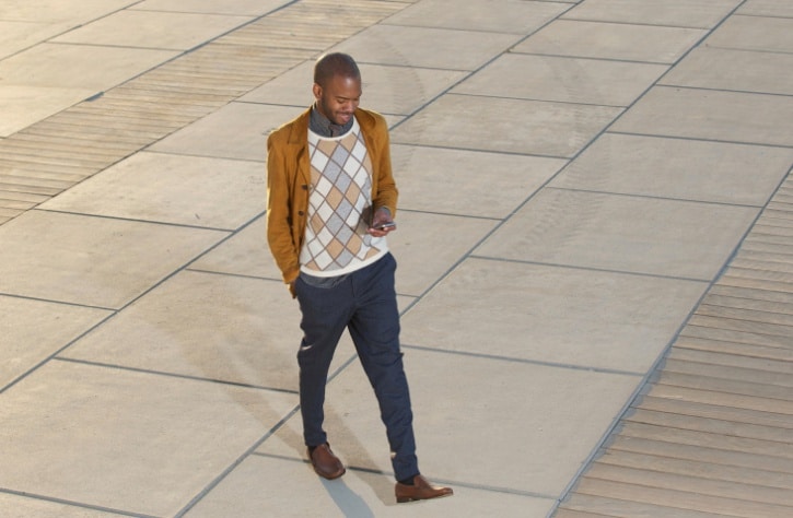 man walking looking at his phone