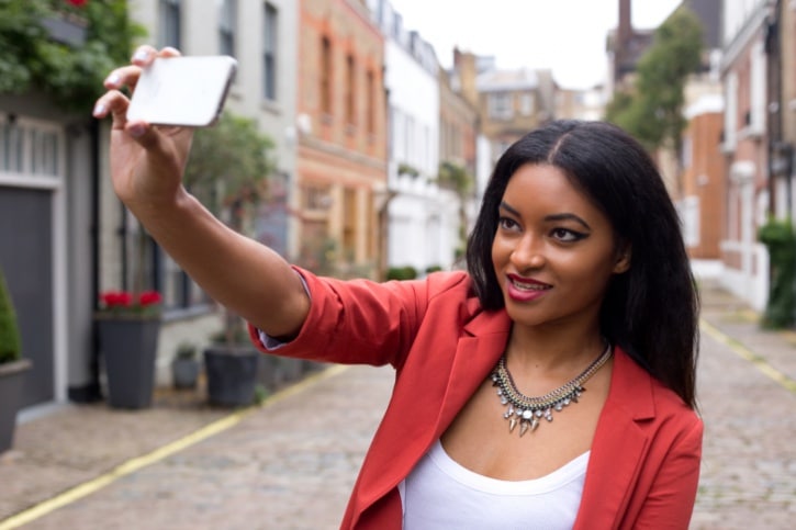 young African American Black woman taking selfie outsidie