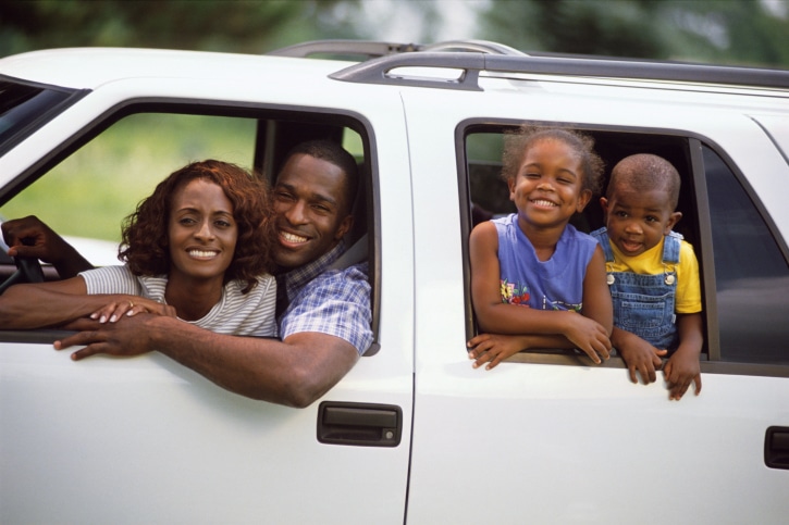 African American Black family with two children riding in SUV truck