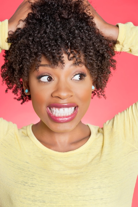 African American woman with hands in curly hair