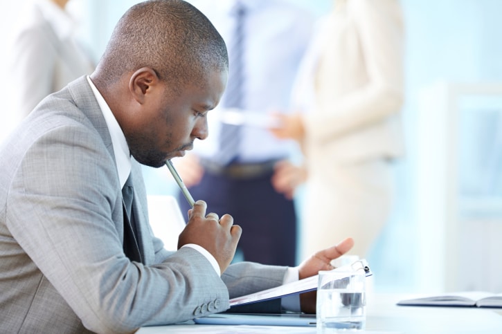 African American businessman looking thoughtful at paper