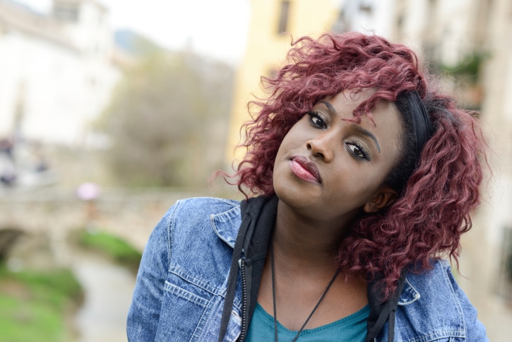 Beautiful black woman in urban background with red hair