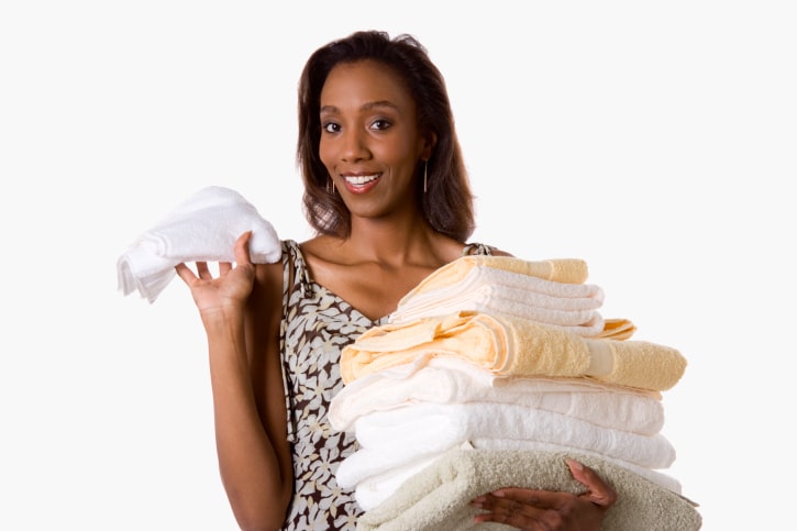 African American woman holding stack of towels