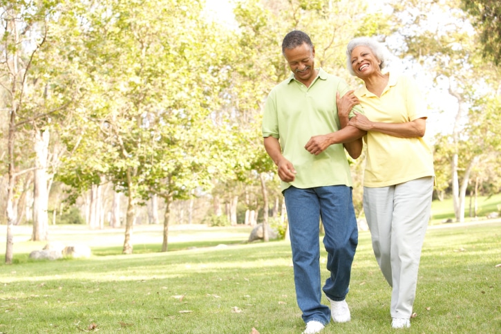 African American senior couple walking in park