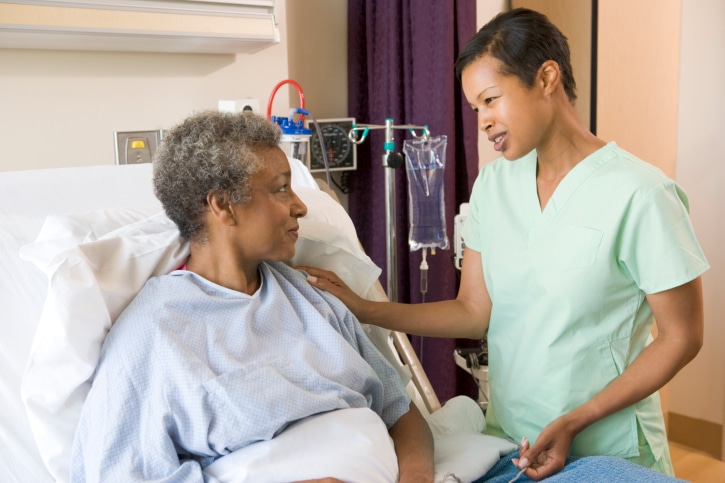 African American nurse talking to senior woman in hospital
