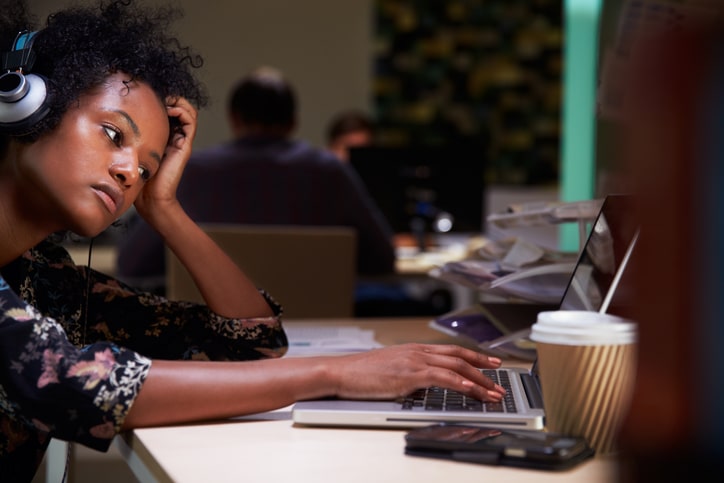 African American woman working late in office on laptop
