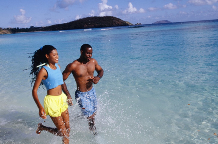 African American couple running in water beach