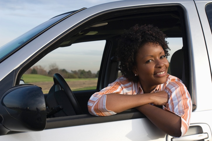 African American woman leaning out car window smiling