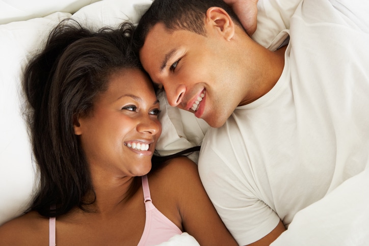 African American couple relaxing in bed