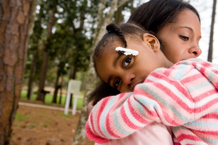 African American mother hugging daughter